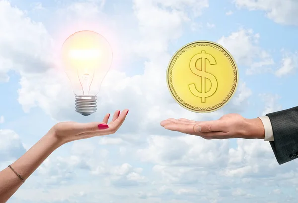 Ampul ve bulut zemin üzerine altın sikke ile el