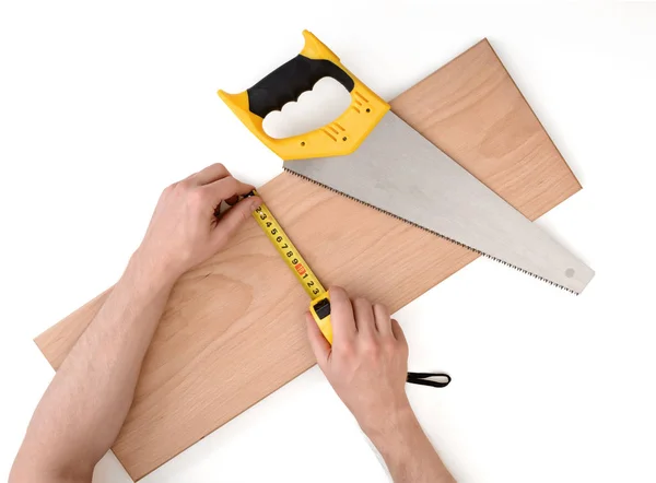 Vista de perto de um homem mãos medindo prancha de madeira com linha de fita, isolado no fundo branco — Fotografia de Stock