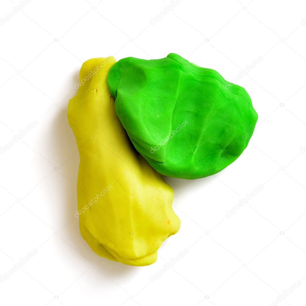 Two pieces of plasticine, yellow and green, isolated on a white background