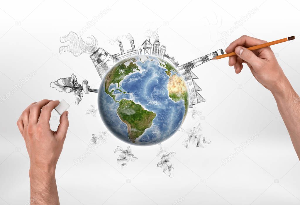 Hands of man drawing a factory and erasing trees on the globe.