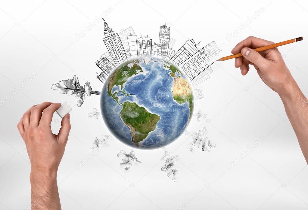 Hands of man drawing buildings and erasing trees on the globe.