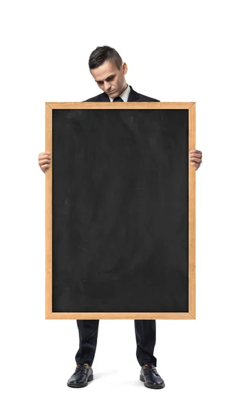 伤心的商人持有空的黑板，孤立在白色的背景 — 图库照片