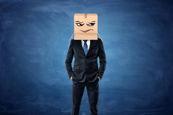 Businessman wearing cardboard box with drawn frowning face on his head — Stock Photo, Image