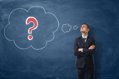 İşadamı nerede düşünceler kabarcıkları ile kırmızı bir soru işareti tebeşirle çizilmiş mavi yazı tahtası arka plan üzerinde.