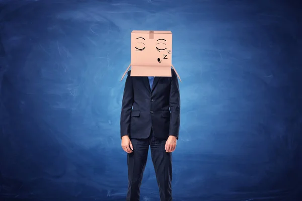 Uomo d'affari indossa una scatola di cartone sulla testa con la faccia assonnata — Foto Stock