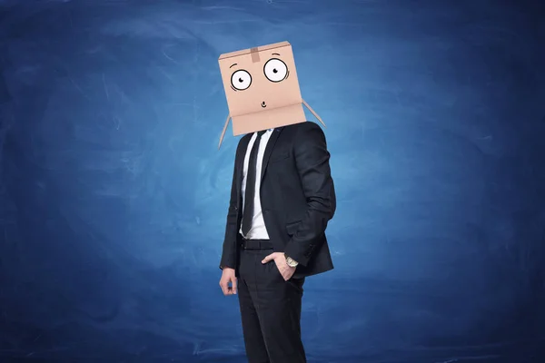 Uomo d'affari indossa una scatola di cartone in testa con una faccia sorpresa disegnata — Foto Stock