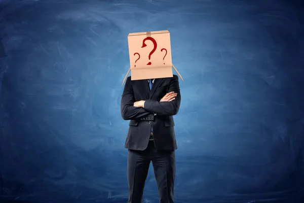 Επιχειρηματίας φορώντας κουτί από χαρτόνι με συμένος ερωτηματικά στο κεφάλι του — Φωτογραφία Αρχείου