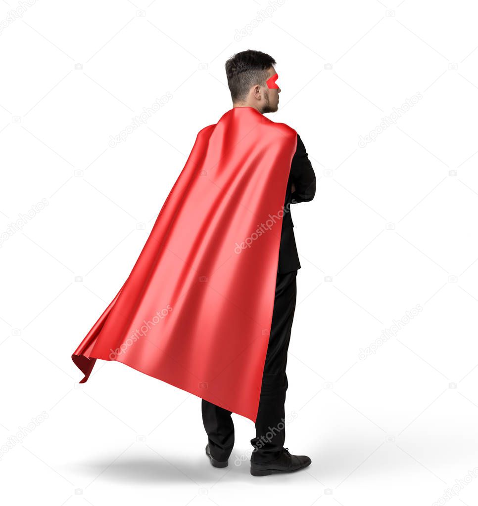 A lone businessman in red flowing cape in side 45 degrees view on white background.