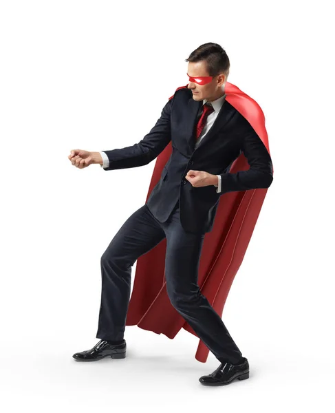 En affärsman som bär en superhjälte mask och röd cape holding ett osynligt rep. — Stockfoto