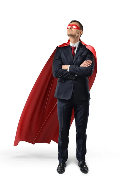 En affärsman i en officiella kostym och röd cape med händerna korsade och tittar upp. — Stockfoto