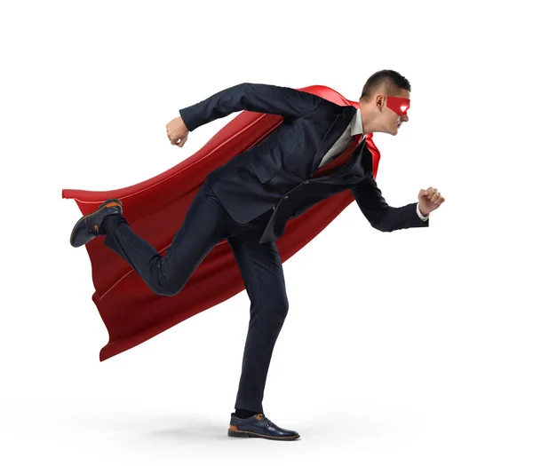 En affärsman i en hero röd cape och en mask i side se redo att köra med ena benet redan i luften på vit bakgrund. — Stockfoto