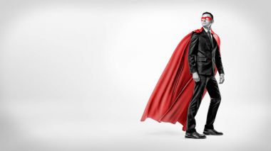 Arka plan beyaz bir akan içinde kırmızı işadamı süper kahraman pelerin ve omzunun üzerinden bakarak bir maske.