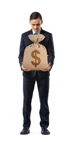 Bir işadamı bir dolar işareti olan bir torba tutarak beyaz arka plan üzerinde basılı. — Stok fotoğraf