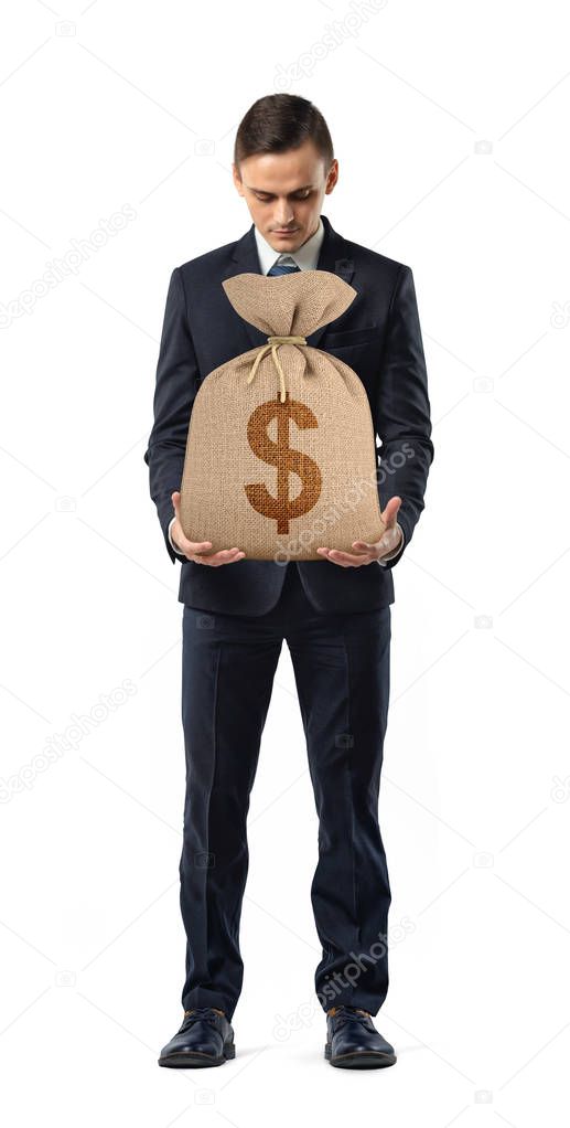 A businessman on white background holding a sack with a dollar sign printed on it.