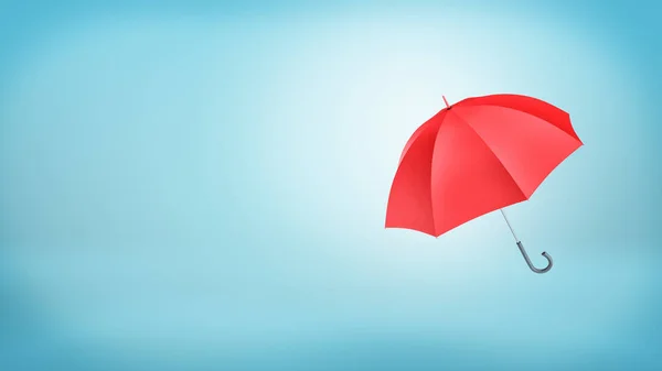 Un parapluie rouge classique ouvert avec une poignée placée verticalement sur fond bleu . — Photo