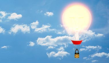 Bulutlu gökyüzü arka plan üzerinde bir akkor ampul yerine onun zarf ile bir sıcak hava balonu.