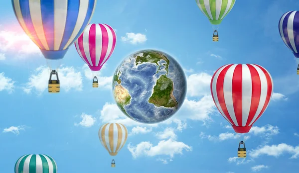 An Earth globe on cloudy sky background surrounded by many large hot air balloons. — Stock Photo, Image