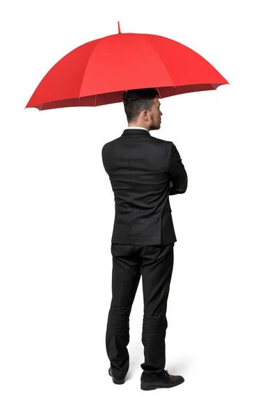 Un homme d'affaires isolé, le dos tourné sous un parapluie rouge . — Photo