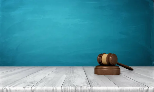 3d renderização de um martelo juiz de madeira marrom e bloco de som deitado em uma mesa de madeira contra fundo azul . — Fotografia de Stock
