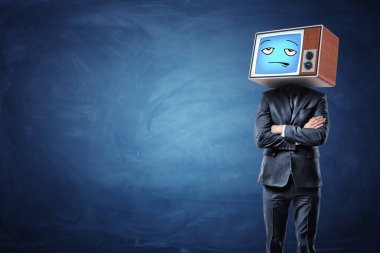 Bir işadamı katlanmış elleriniz ve kafasında bir mavi sıkılmış ifade gösteren eski bir Tv.