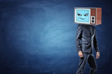 Bir iş adamı yarı açık ve kafasına bir şüpheci ifade ile eski bir Tv giyen süre bırakmak hazır duruyor.