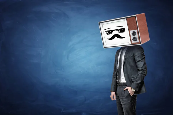 Un uomo d'affari ne ha uno in tasca e indossa una vecchia TV invece della sua testa, mentre mostra un emoticon bianco figo . — Foto Stock