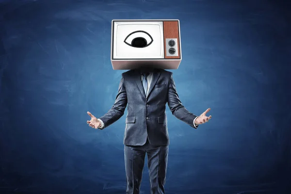 Un hombre de negocios con ambos brazos en frente de él palmas hacia arriba y una cabeza reemplaza por una caja de TV con un ojo en la pantalla . —  Fotos de Stock