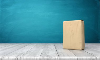tek kapalı çimento torbası 3B oluşturmayı dikey bir ahşap masa mavi arka plan üzerine yerleştirilen.