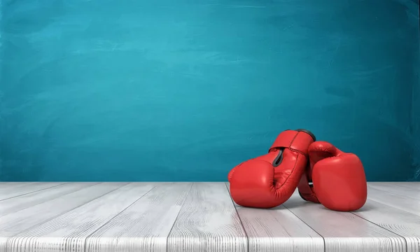 Rendu 3d de deux gants de boxe rouges couchés sur un bureau en bois devant un fond de tableau noir bleu . — Photo