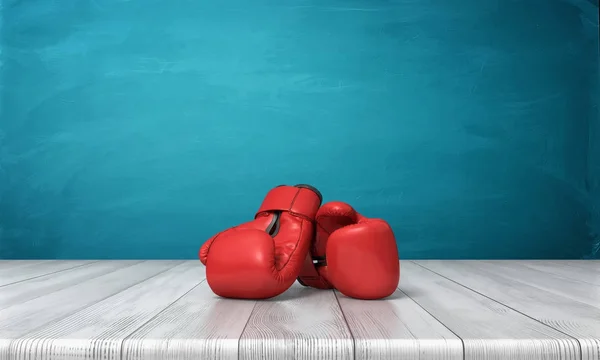 Rendu 3d de deux gants de boxe rouges couchés sur un bureau en bois devant un fond de tableau noir bleu . — Photo