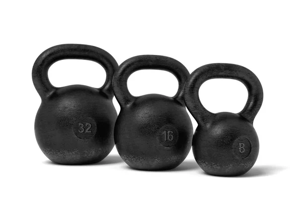 3D vykreslování tři černé železné kettlebells s označením 32, 24 a 16 kg stojící blízko sebe. — Stock fotografie