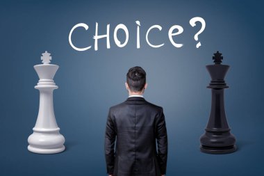 Bir businessmans bir görünüm geri iki satranç Kral ve bir yazı seçim arasında haliyle.