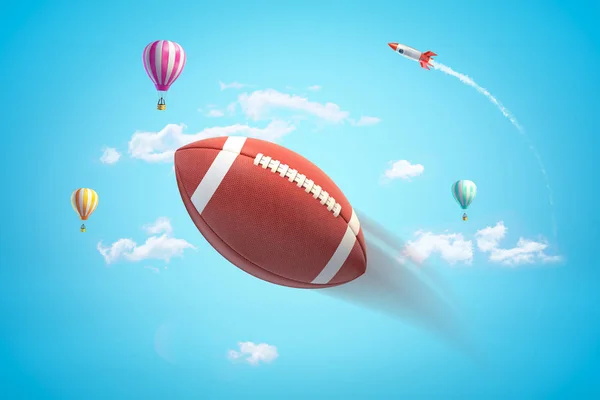 3d representación de cerca de bola ovalada marrón para el fútbol americano en el aire, contra el cielo azul brillante con globos de aire caliente y cohete en la distancia . — Foto de Stock