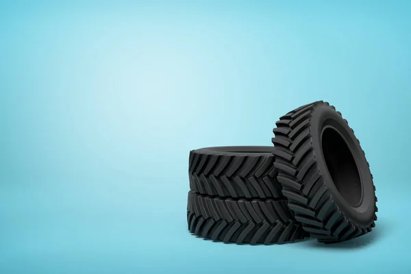 3d rendering of three black wheel tyres stocked on blue background — Stock Photo, Image