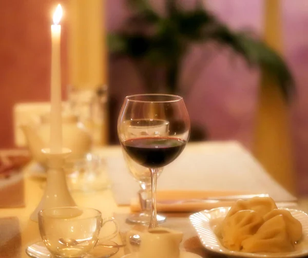 Foto noche romántica mesa con una copa de vino — Foto de Stock