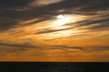 Fotoğraf arkaplanda güzel bir gün batımı akşam deniz kıyısında.