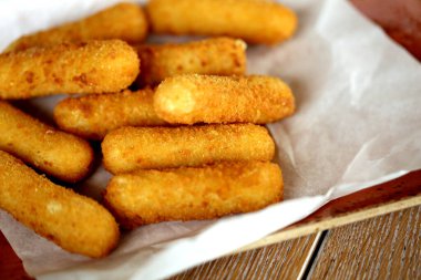 Tabaktaki bir restoranda lezzetli peynirli çubukların fotoğrafı.