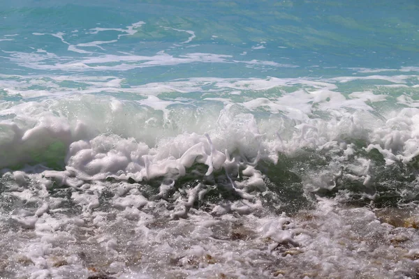 太陽の光に照らされた美しい青い海の波と水しぶき — ストック写真