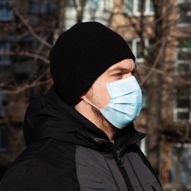 Virüs covid-19. Avrupa 'da bir şehirde maskeli bir adam, kendini koronavirüsten korur.