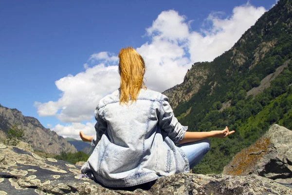 Young woman meditating on top of a mountain in the wilderness — Stock Photo, Image