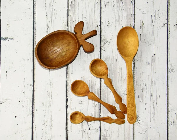 Wooden kitchen spoon and plate on the table, top view — Stock Photo, Image