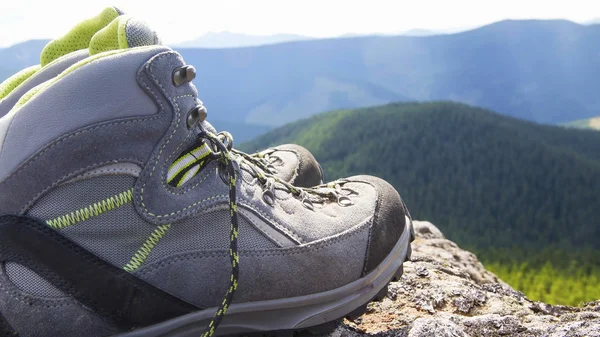 Hiking boots with trekking sticks on the mountain peak — Stock Photo, Image