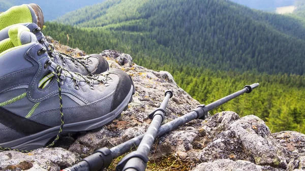 Botas de senderismo con bastones de trekking en la cima de la montaña — Foto de Stock