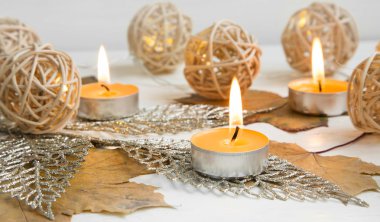 Sonbahar yaprakları ile mumlar ve dekorasyon ışıklar