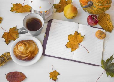 Kurutulmuş yaprakları, çay bardağı, mum fener, sonbahar defter ve ho