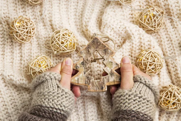 Vrouw handen met wanten en houten boom xmas decoratie — Stockfoto