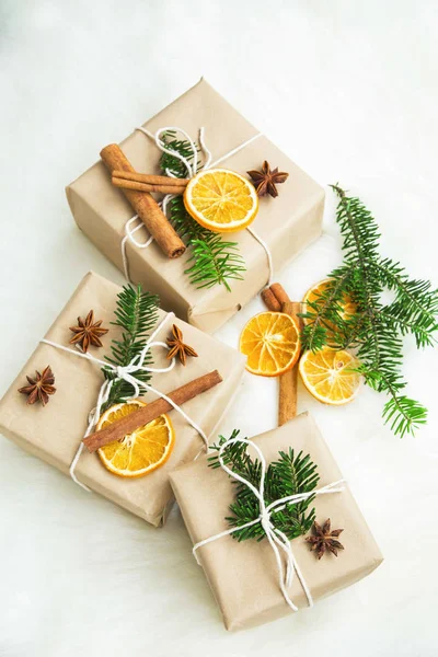 Vánoční retro zabalené dárky s kořením, sušené pomerančové řezy a — Stock fotografie