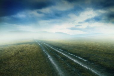 Kasvetli kirli ülkede yol çayır sis ve dramatik cloudsca ile