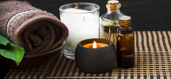 Spa bodegón con toalla, velas, aceite de baño y botella de esencia — Foto de Stock