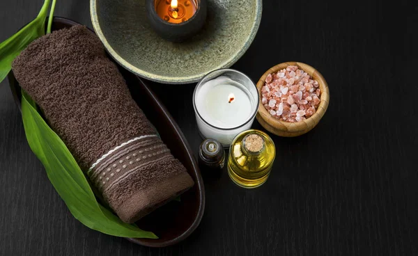El establecimiento de spa bodegón con vela, aceite de baño, toalla y l verde —  Fotos de Stock
